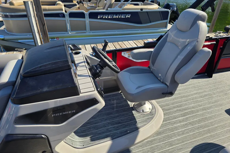 Slide: The Image of 2025 Premier 210 SunSation RE boat interior with captain's chair and steering console. - 10