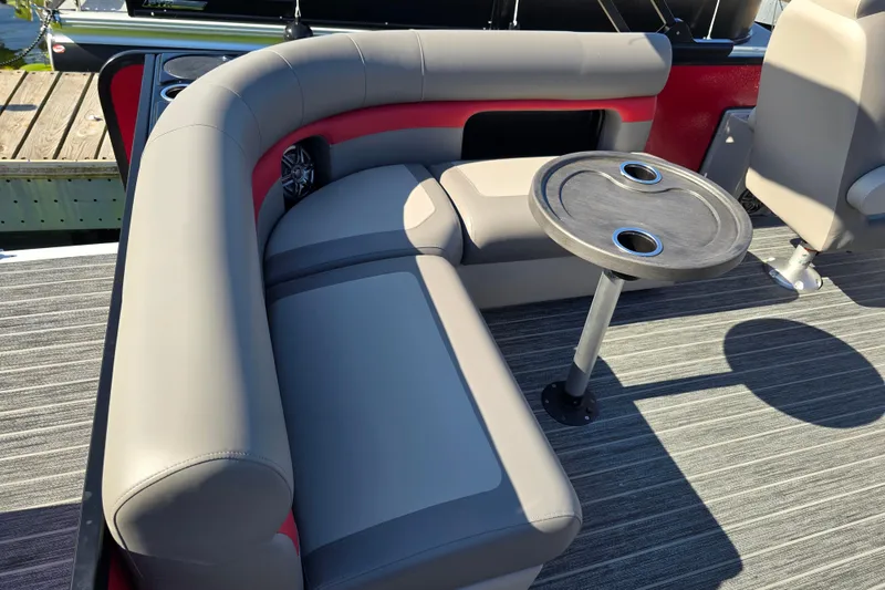 Slide: The Image of Luxurious seating area on 2025 Premier 210 SunSation RE pontoon boat with table and cup holders. - 14
