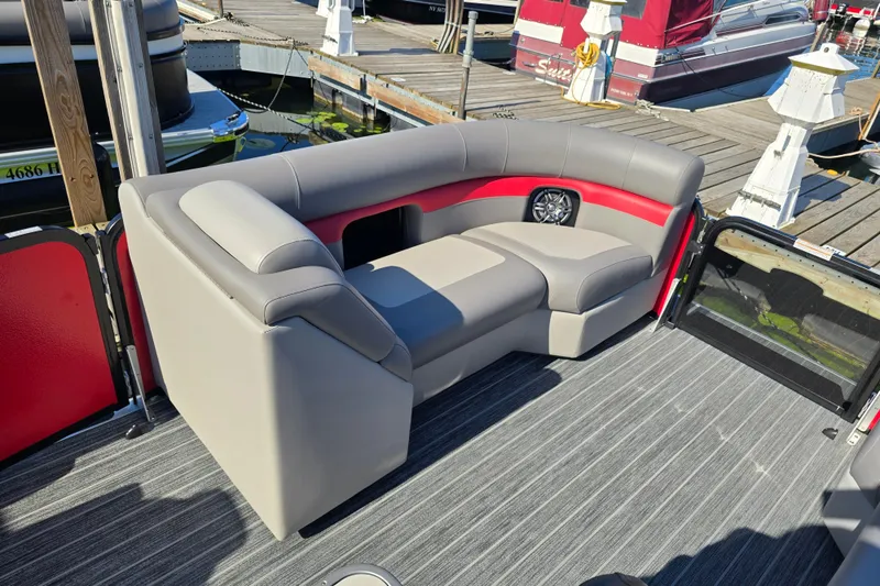 Slide: The Image of Premier 210 SunSation RE 2025 pontoon boat interior with gray and red seating at dock. - 17