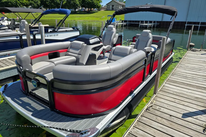 Slide: The Image of 2025 Premier 210 SunSation RE pontoon boat docked, featuring sleek red and gray design. - 3