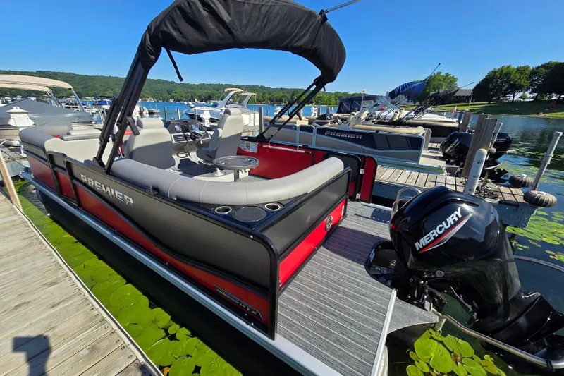 Slide: The Image of 2025 Premier 210 SunSation RE pontoon boat docked with Mercury engine. - 4