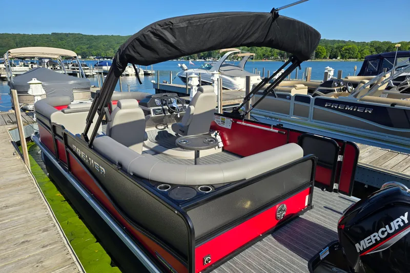 Slide: The Image of 2025 Premier 210 SunSation RE pontoon boat docked at a marina. - 5