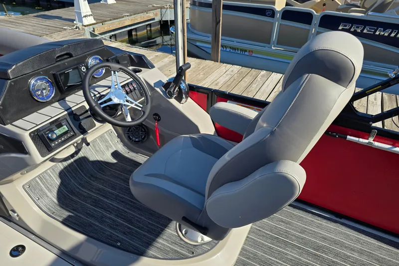 Slide: The Image of 2025 Premier 210 SunSation RE boat interior with steering wheel and captain's chair. - 9