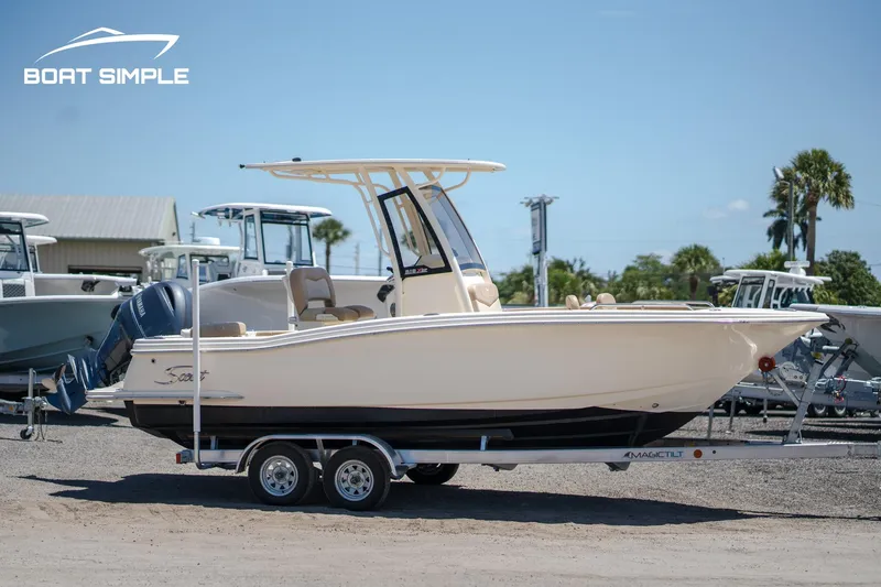 Slide: The Image of 2023 Scout 215 XSF boat on trailer, side view, outdoors. - 2