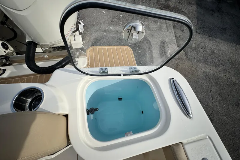 Slide: The Image of Open livewell on 2026 Scout 260 LXF boat, featuring a clear lid and blue interior. - 13