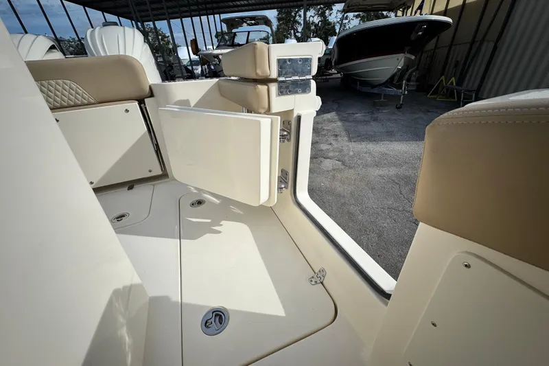 Slide: The Image of 2026 Scout 260 LXF boat interior with open storage compartment and beige seating. - 14