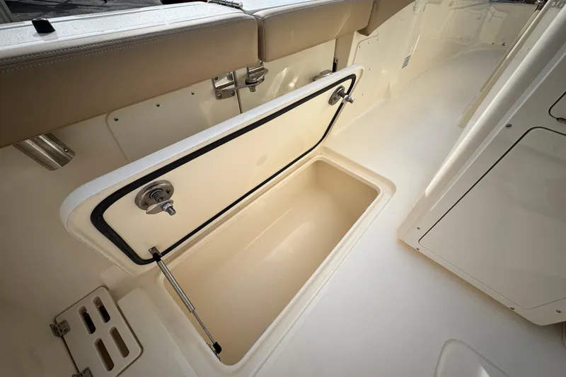 Slide: The Image of 2026 Scout 260 LXF boat storage compartment with open hatch, beige interior. - 15