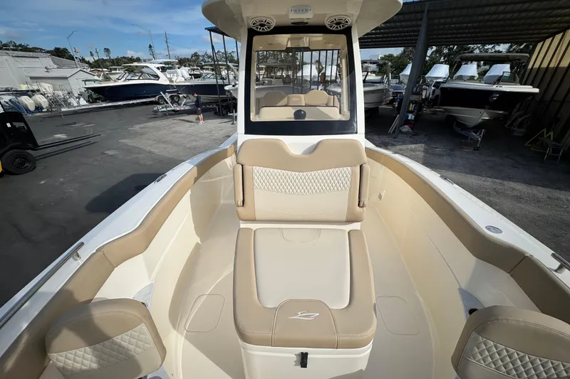 Slide: The Image of 2026 Scout 260 LXF boat interior with beige seating, docked among other boats. - 22