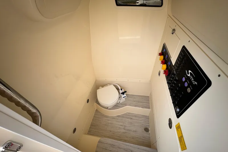 Slide: The Image of Interior of 2026 Scout 260 LXF boat featuring a compact bathroom with control panel. - 24