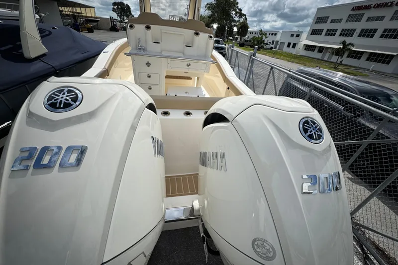 Slide: The Image of 2026 Scout 260 LXF boat with dual Yamaha 200 engines, parked near a fence. - 26