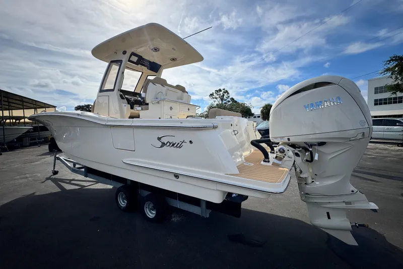 Slide: The Image of 2026 Scout 260 LXF boat with Yamaha engine, parked outdoors under a cloudy sky. - 4