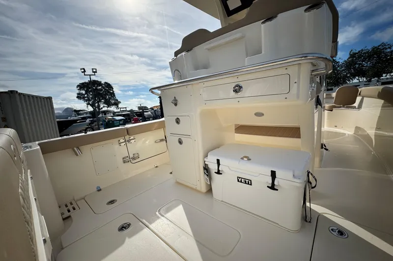 Slide: The Image of 2026 Scout 260 LXF boat interior with storage and Yeti cooler under sunny sky. - 9