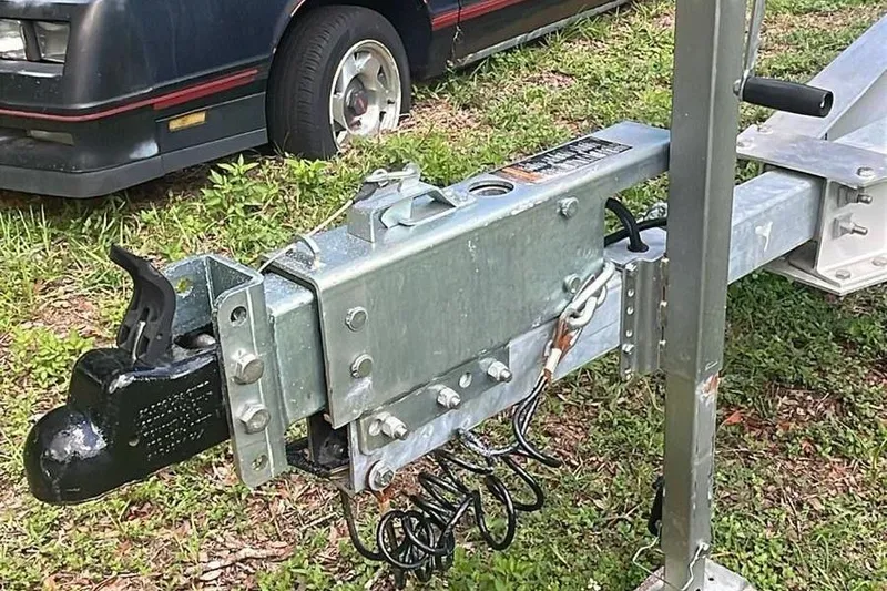 Slide: The Image of Trailer hitch of a 2024 Sportsman Open 252 Center Console, parked on grass. - 12