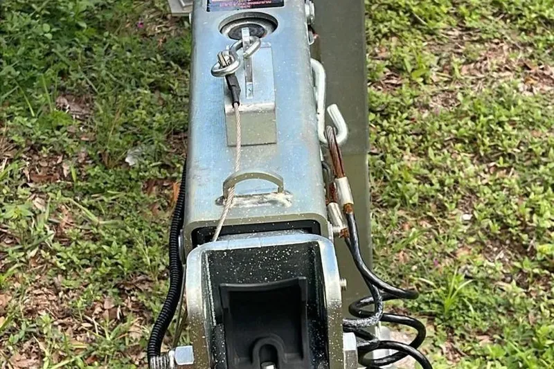 Slide: The Image of Trailer hitch mechanism for 2024 Sportsman Open 252 Center Console boat on grass. - 14