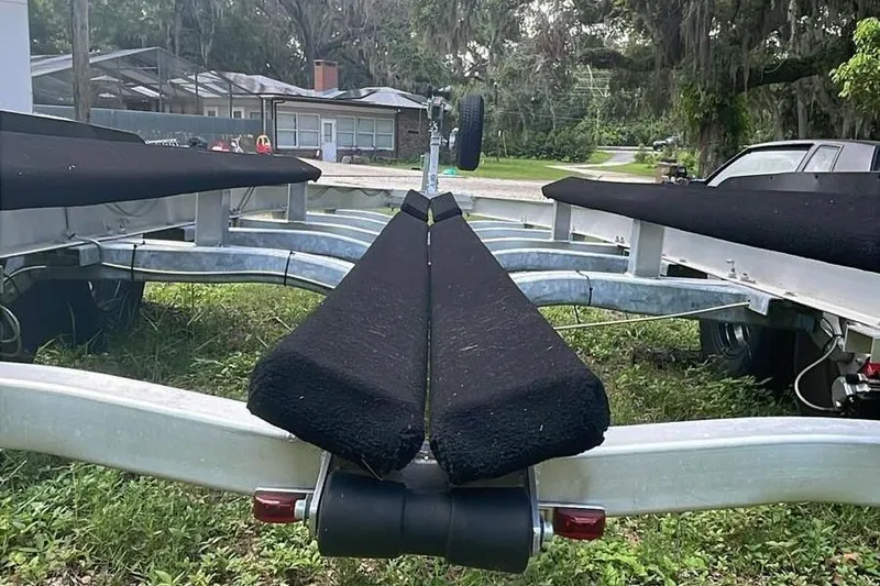 Slide: The Image of Trailer for 2024 Sportsman Open 252 Center Console boat, parked on grass. - 16