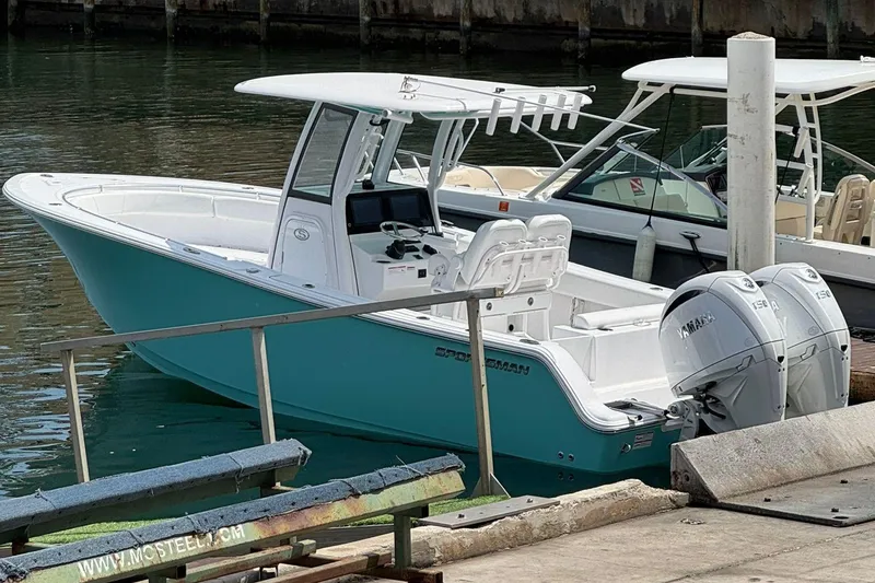 Slide: The Image of 2024 Sportsman Open 252 Center Console boat docked with twin Yamaha engines. - 2