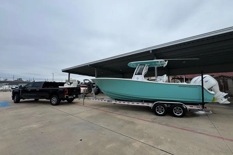 Slide: The Image of 2024 Sportsman Open 252 Center Console boat on trailer, towed by a black truck. - 4