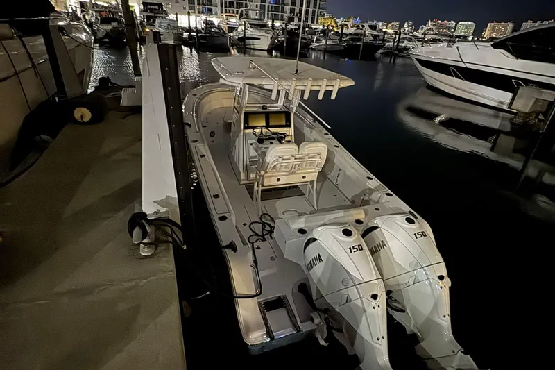 Slide: The Image of 2024 Sportsman Open 252 Center Console boat docked at night with twin Yamaha engines. - 7