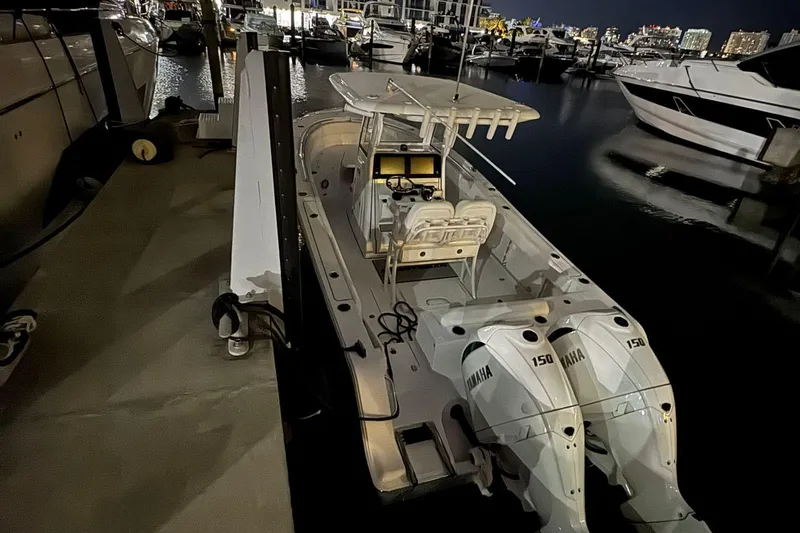 Slide: The Image of 2024 Sportsman Open 252 Center Console boat docked at night with twin Yamaha engines. - 8