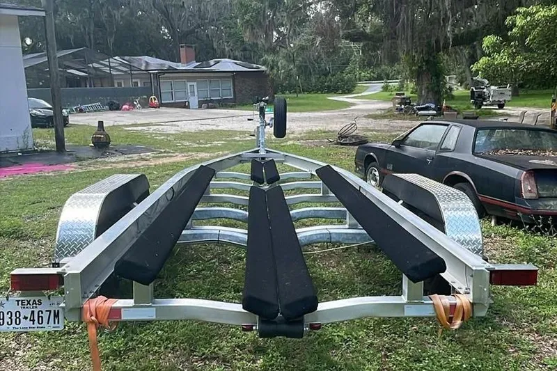 Slide: The Image of 2024 Sportsman Open 252 Center Console trailer parked in a grassy yard. - 9