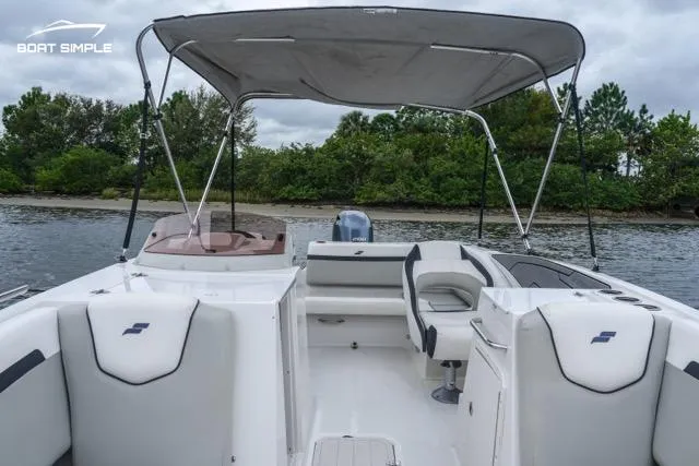 Slide: The Image of 2023 Starcraft SVX 231 OB DH boat interior with canopy on a calm lake. - 10