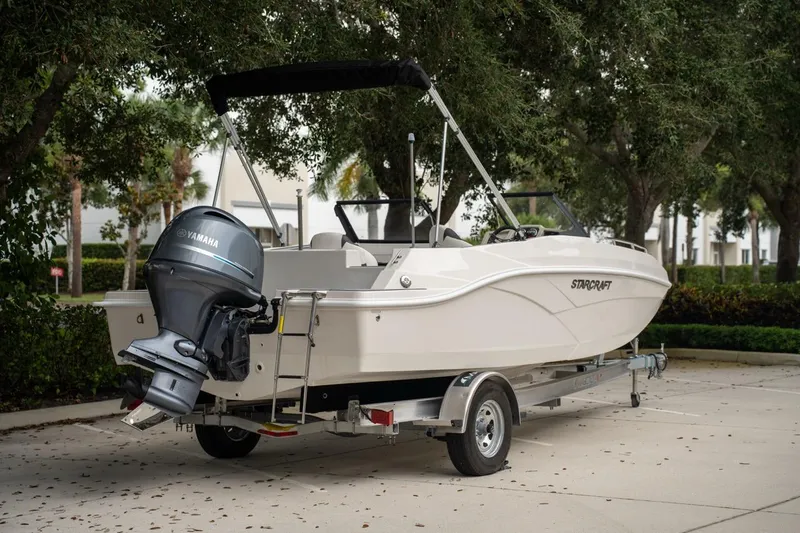 Slide: The Image of 2022 Starcraft SVX 190 DC boat on trailer with Yamaha outboard motor, parked outdoors. - 2