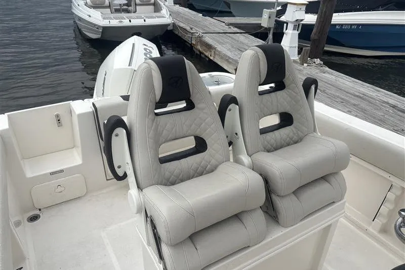 Slide: The Image of 2024 Sailfish 241 CC boat with dual cushioned seats at the dock. - 2