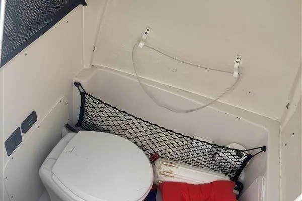 Slide: The Image of 2024 Sailfish 241 CC boat interior with toilet and storage net. - 3