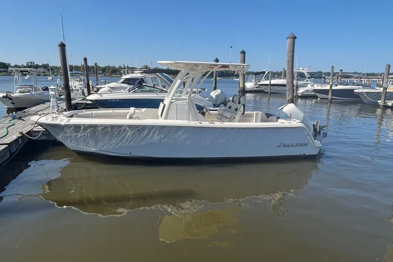 Slide: The Image of 2024 Sailfish 241 CC boat docked in a marina under clear blue skies. - 8
