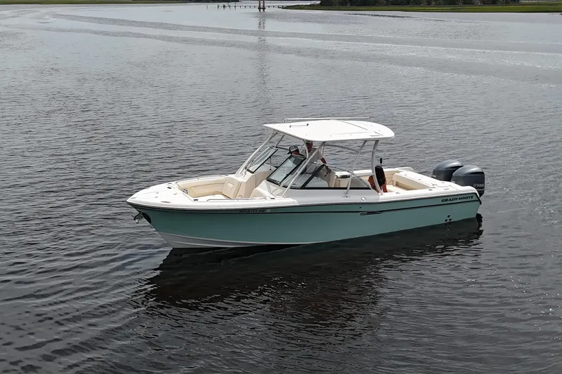 Slide: The Image of 2015 Grady-White Freedom 285 boat on calm water, featuring dual outboard engines. - 1