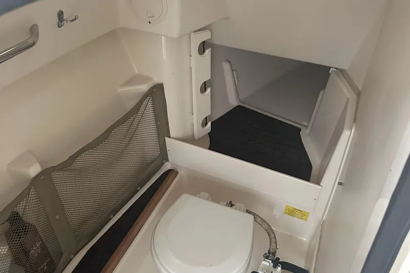 Slide: The Image of 2015 Grady-White Freedom 285 boat interior with compact toilet and storage area. - 8