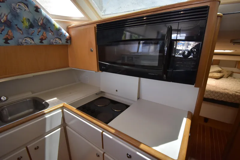 Slide: The Image of kitchen in a 1997 Tiara 4300 yacht with stove, microwave, and sink. - 15
