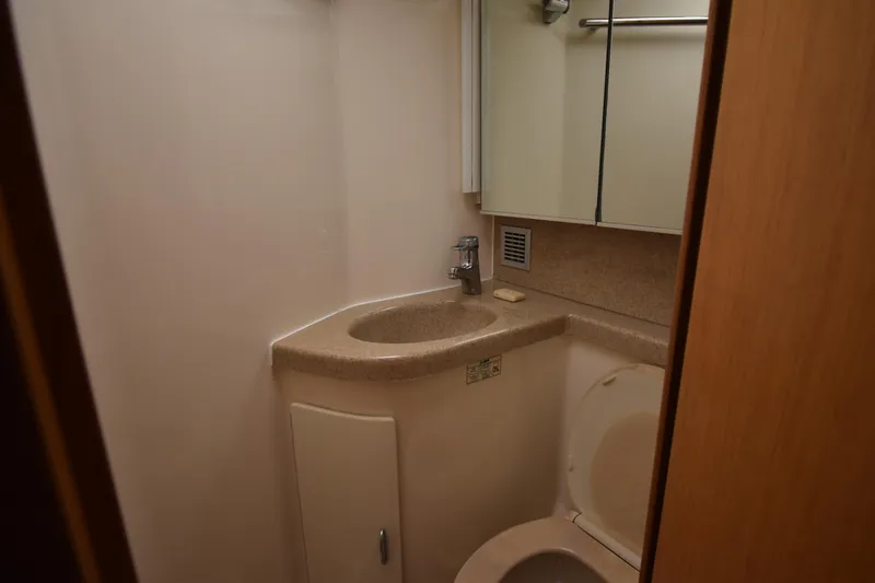 Slide: The Image of Compact bathroom in 1997 Tiara 4300 yacht with sink, toilet, and mirrored cabinet. - 18