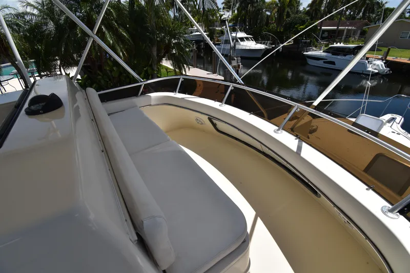 Slide: The Image of 1997 Tiara 4300 yacht deck with seating, docked near lush greenery and other boats. - 35