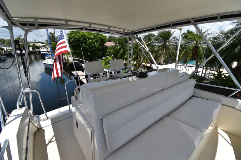 Slide: The Image of 1997 Tiara 4300 yacht deck with seating, American flag, and waterfront view. - 5