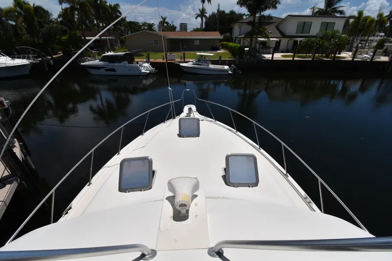 Slide: The Image of Bow view of a 1997 Tiara 4300 yacht docked in a serene marina. - 7