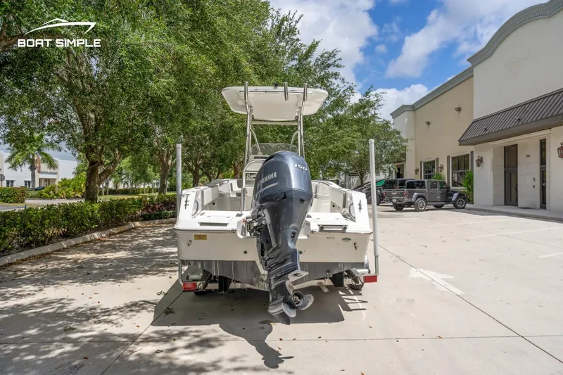 Slide: The Image of 2020 Release 210 RX boat with Yamaha engine, parked outdoors near buildings and trees. - 6