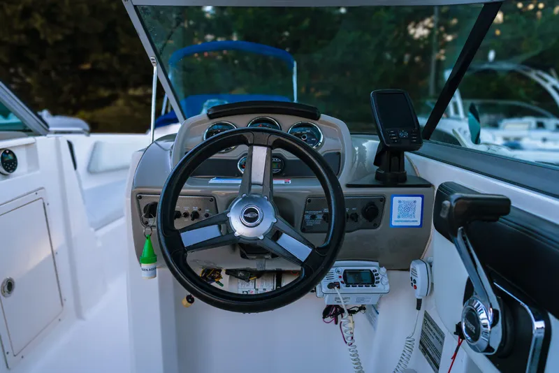 Slide: The Image of 2018 Chaparral 210 Suncoast boat dashboard with steering wheel and controls. - 2