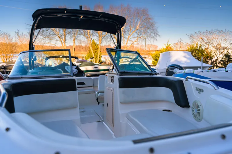 Slide: The Image of 2018 Chaparral 210 Suncoast boat interior with seating and windshield, outdoors. - 5