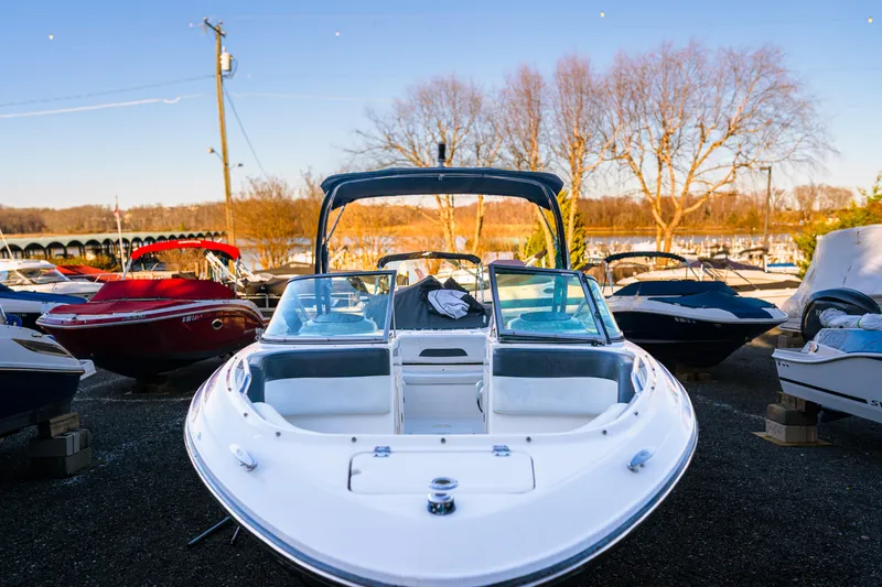 Slide: The Image of 2018 Chaparral 210 Suncoast boat displayed outdoors among other boats. - 6