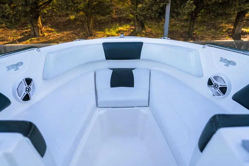 Slide: The Image of 2018 Chaparral 210 Suncoast boat interior with white seating and speakers. - 6