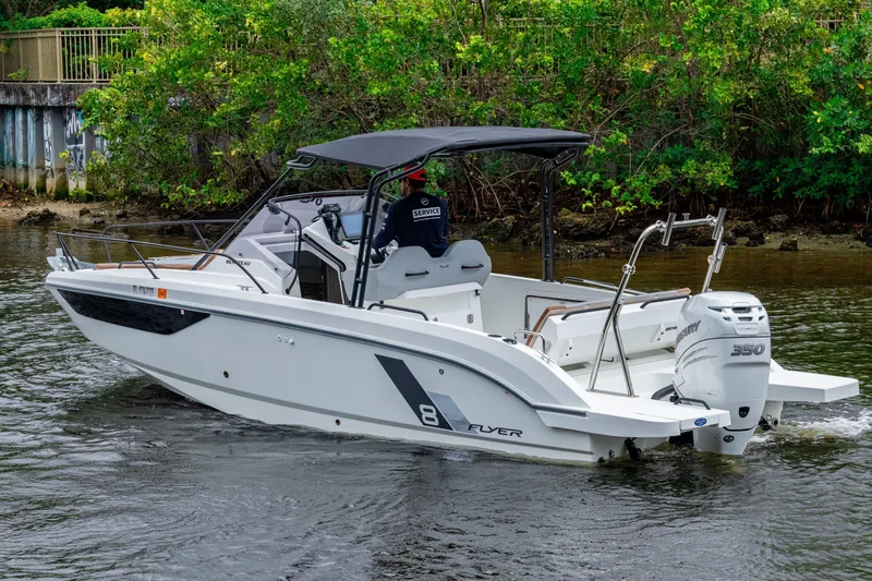 Slide: The Image of 2022 Beneteau America Flyer 8 Sundeck boat cruising on a river with lush greenery. - 20