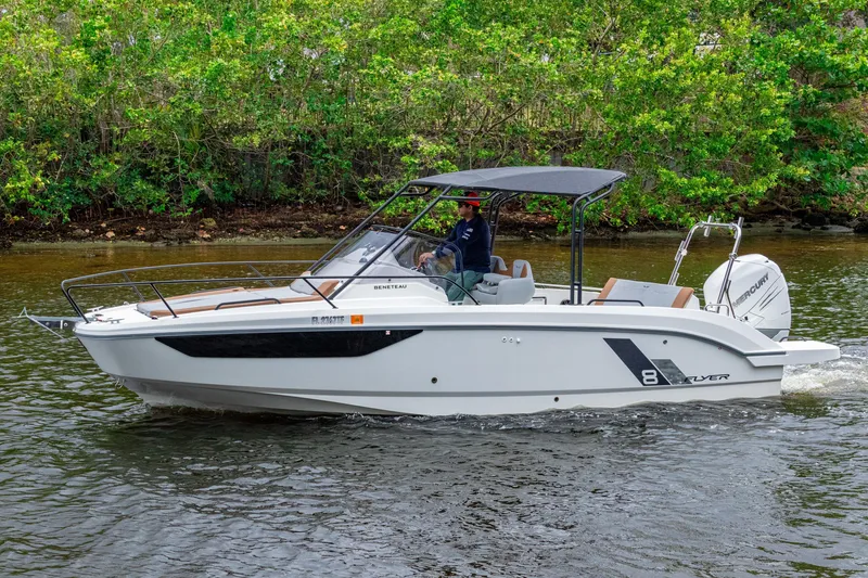 Slide: The Image of 2022 Beneteau America Flyer 8 Sundeck boat cruising on a river with lush greenery. - 21