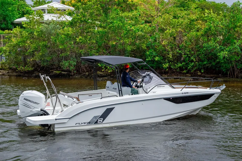 Slide: The Image of 2022 Beneteau America Flyer 8 Sundeck boat cruising on a river with lush greenery. - 3