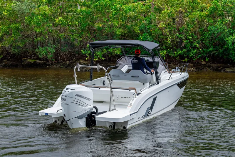 Slide: The Image of 2022 Beneteau America Flyer 8 Sundeck boat cruising on a river near lush greenery. - 4