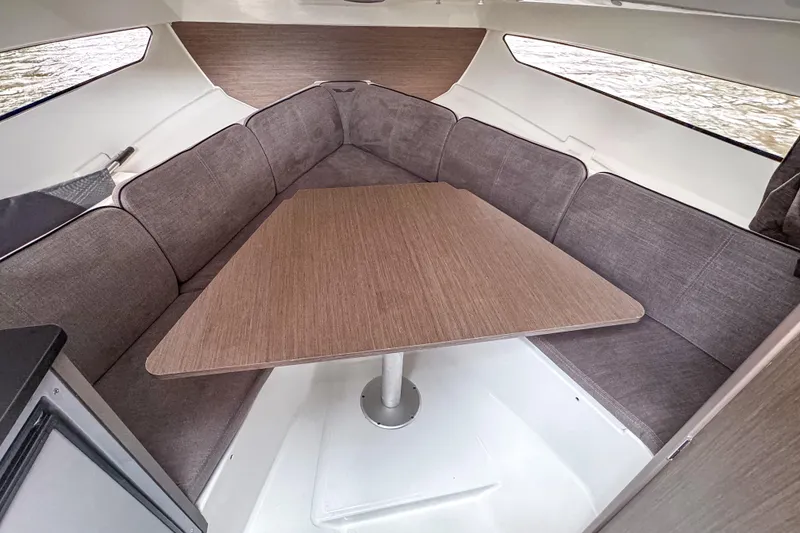 Slide: The Image of 2022 Beneteau America Flyer 8 Sundeck interior with cozy seating and wooden table. - 9
