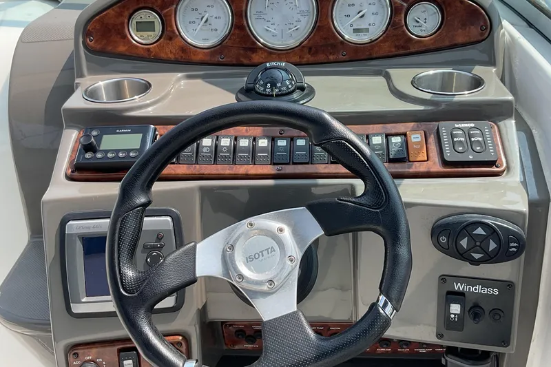 Slide: The Image of 2013 Rinker 290 Express Cruiser dashboard with steering wheel and control panel. - 12