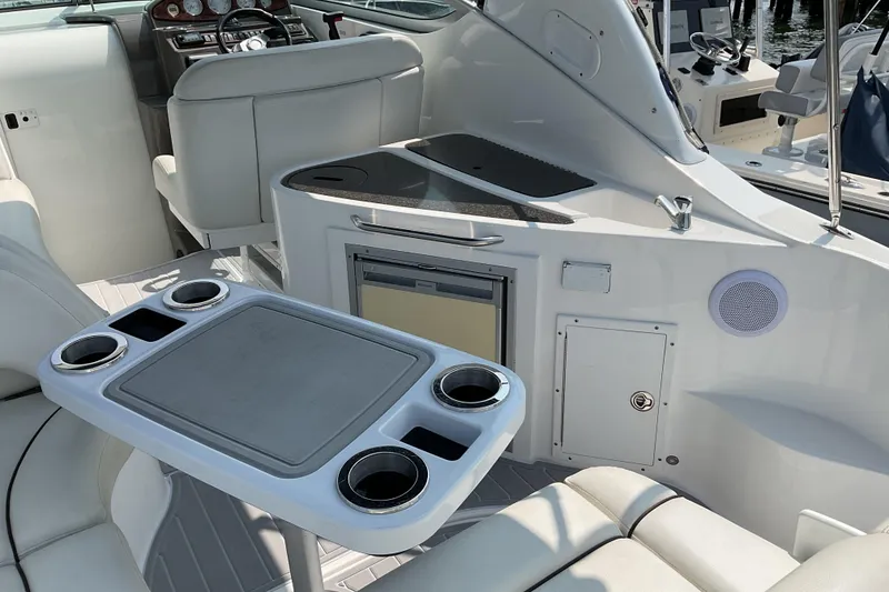 Slide: The Image of 2013 Rinker 290 Express Cruiser interior with seating, table, and kitchenette area. - 14