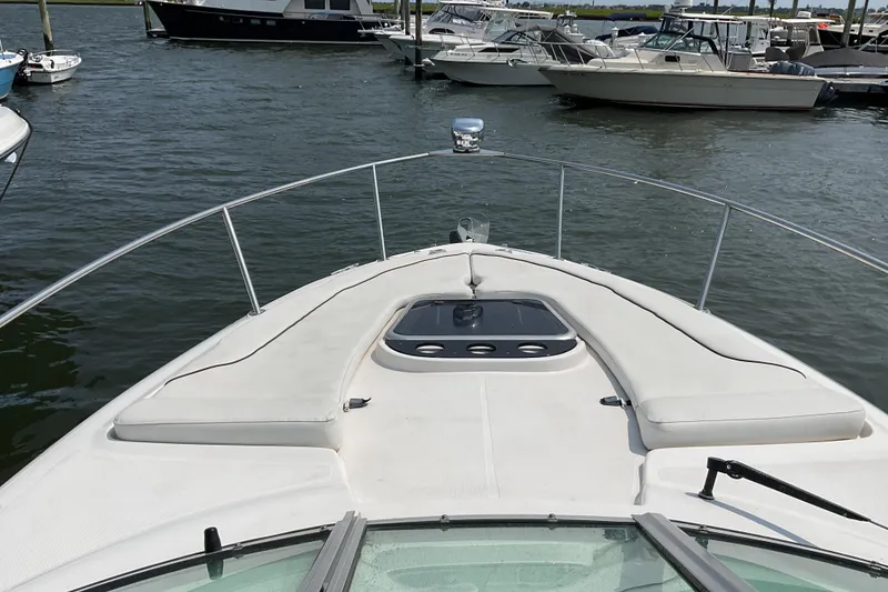 Slide: The Image of 2013 Rinker 290 Express Cruiser docked in a marina, surrounded by other boats. - 15