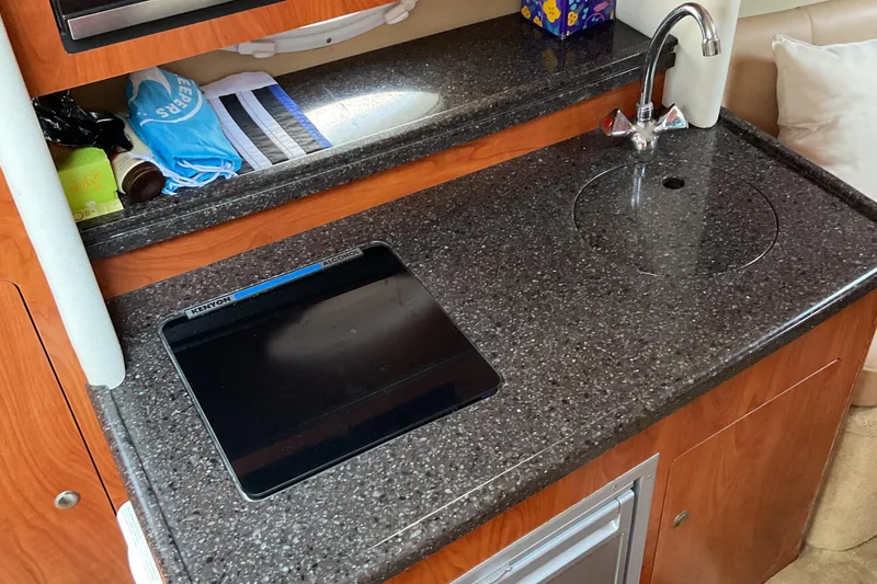 Slide: The Image of 2013 Rinker 290 Express Cruiser kitchen with sink and countertop. - 18